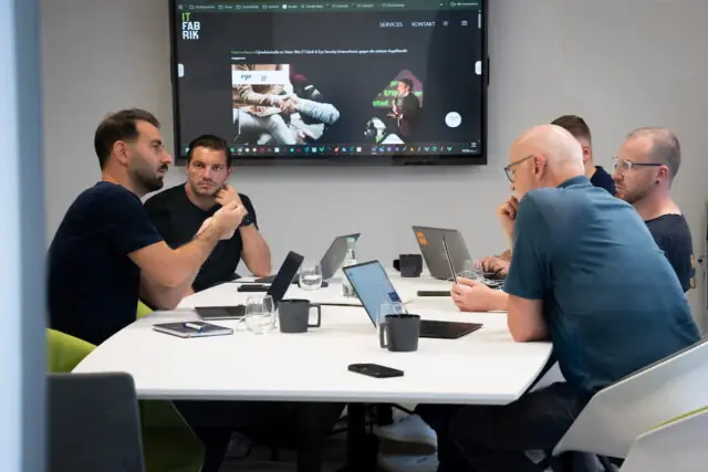 Mitarbeiter von Eye Security und der IT Fabrik sitzen gemeinsam an einem Tisch und unterhalten sich.